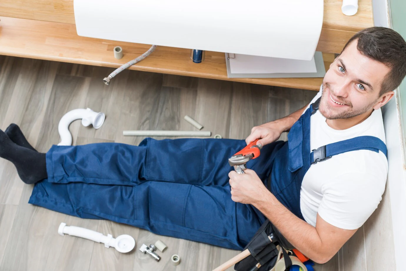 man werkt aan riolering in de badkamer